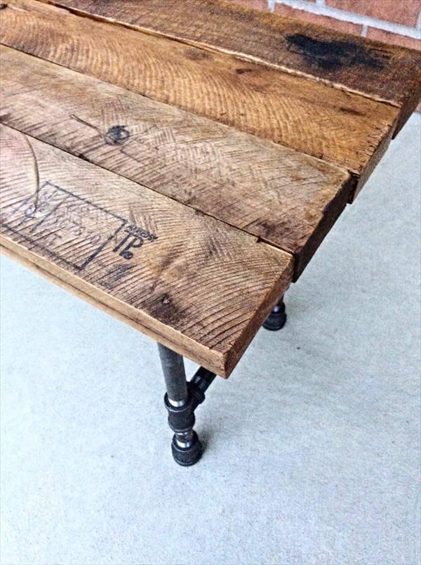 salvaged pallet and iron pipe bench